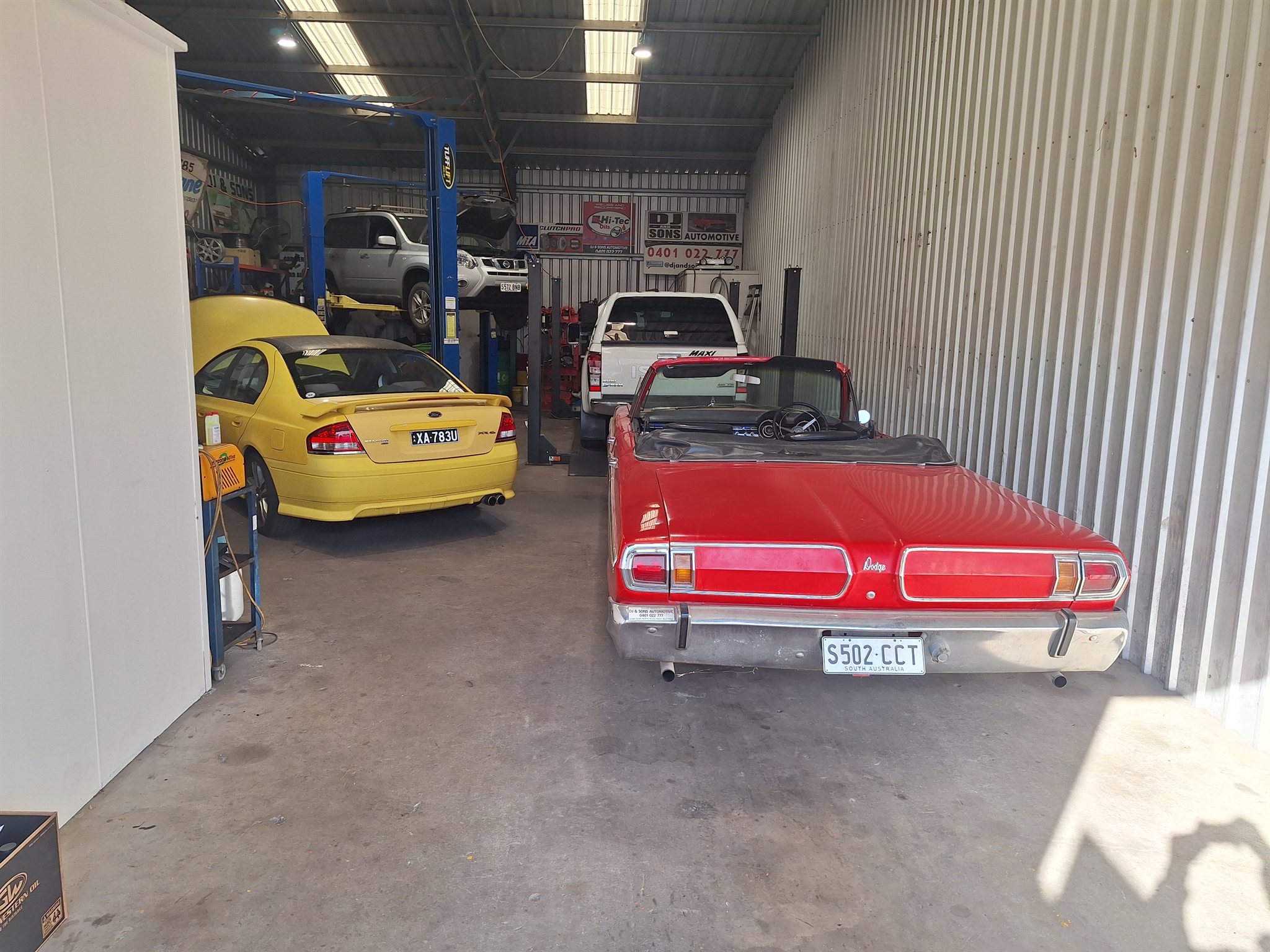 Vehicles being serviced inside the DJ and Sons Automotive workshop